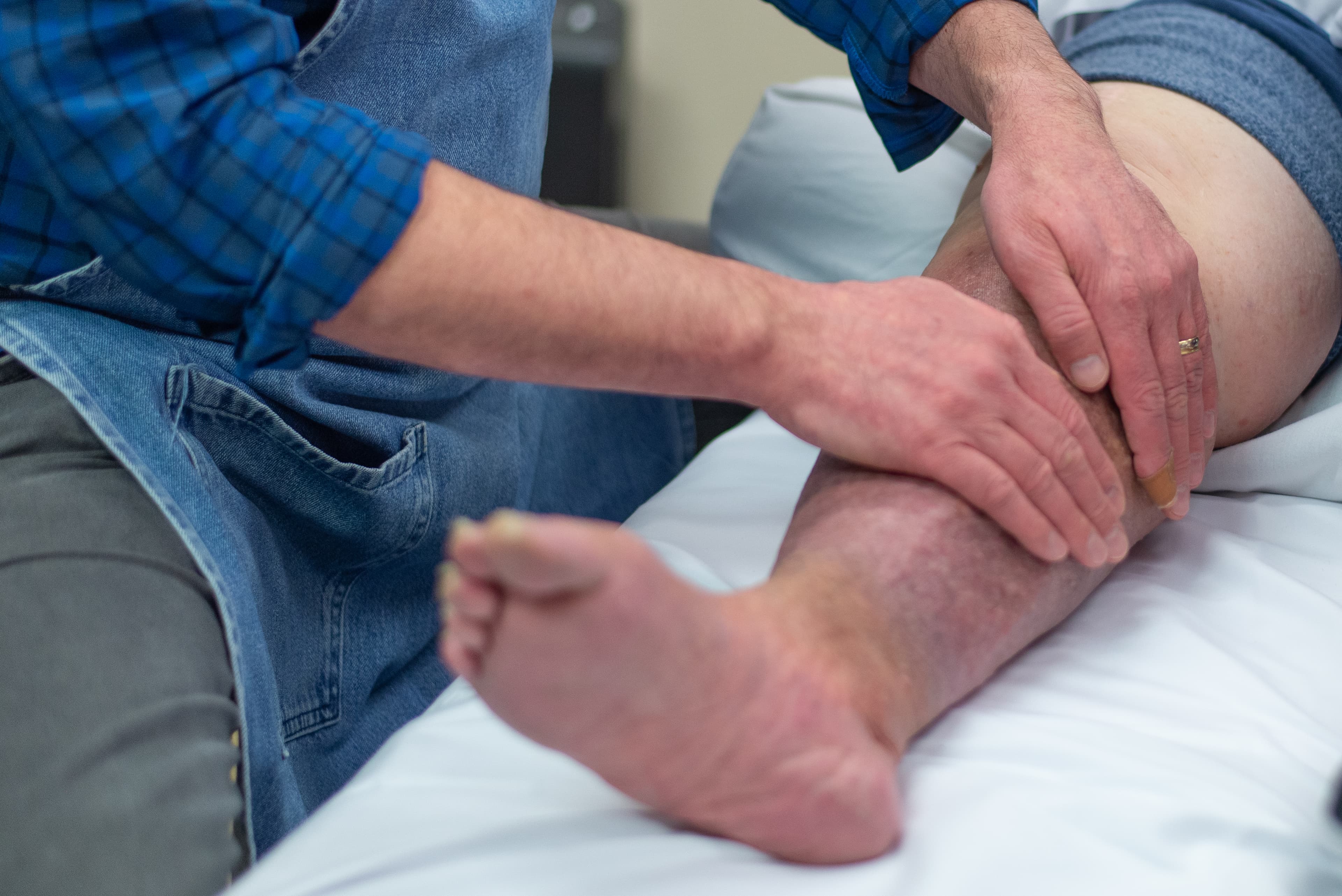 John massaging a patient's leg in one of the treatment rooms.
