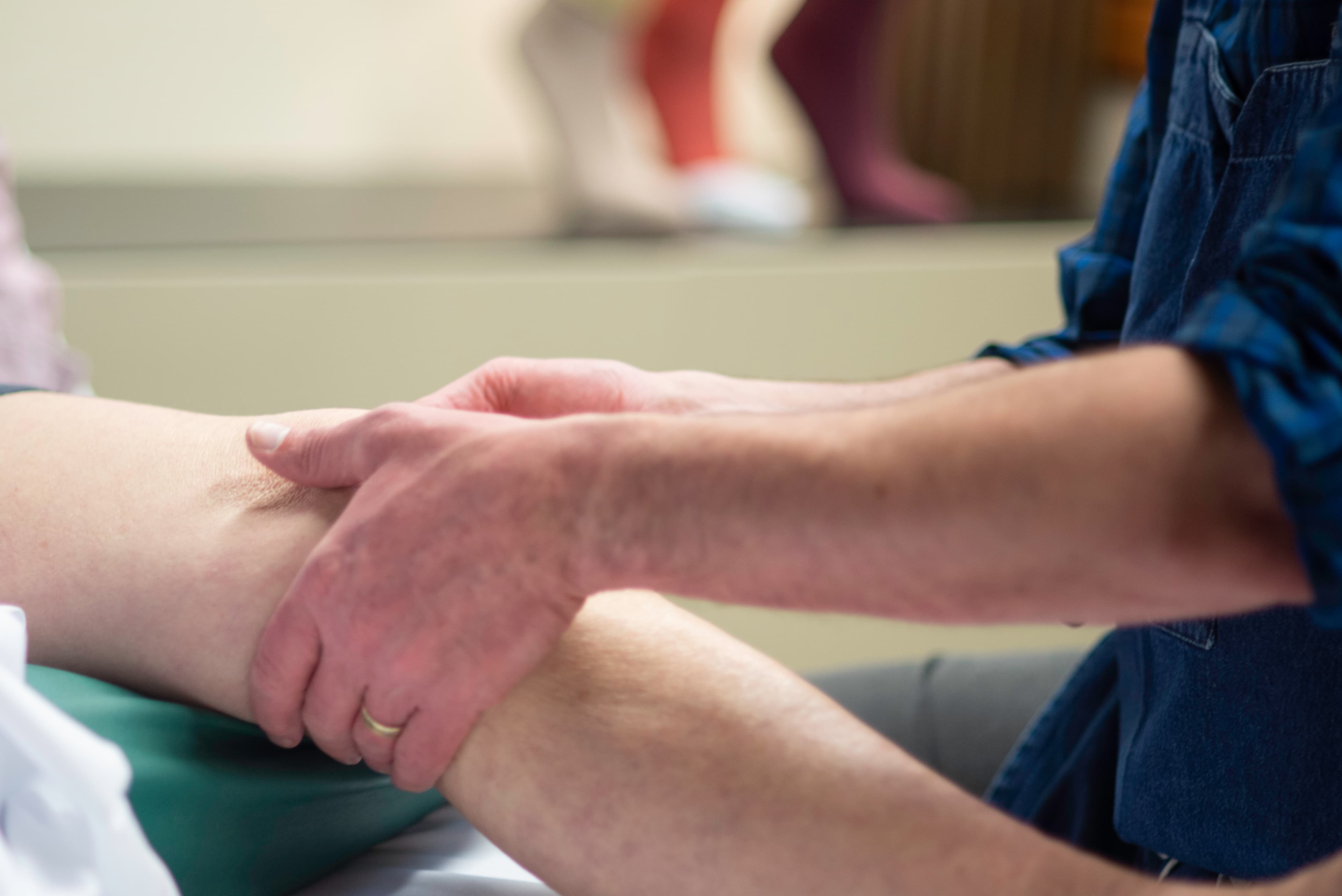 John massaging a patient's leg in one of the treatment rooms.